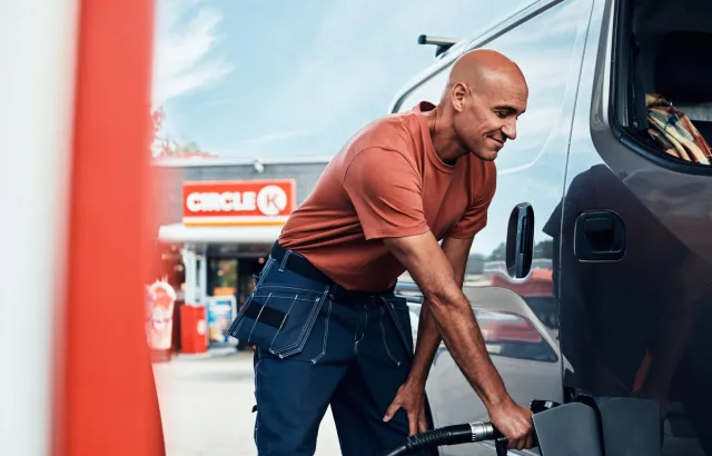 Man happily filling car with fuel at Circle K station