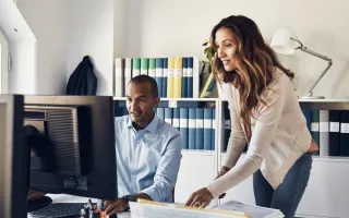 People looking excitedly looking at computer in office