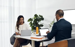 Woman and man sitting at their desk looking at terms and conditions