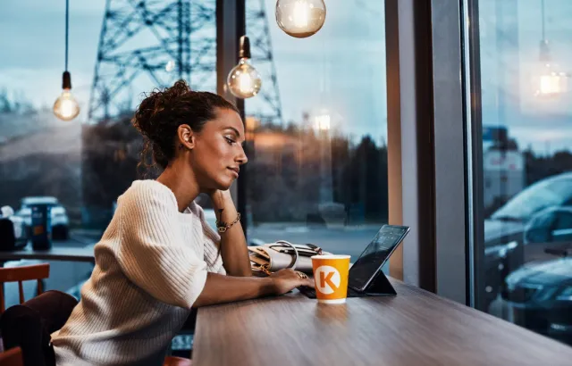 Woman on her tablet in a Circle K café, with a coffee
